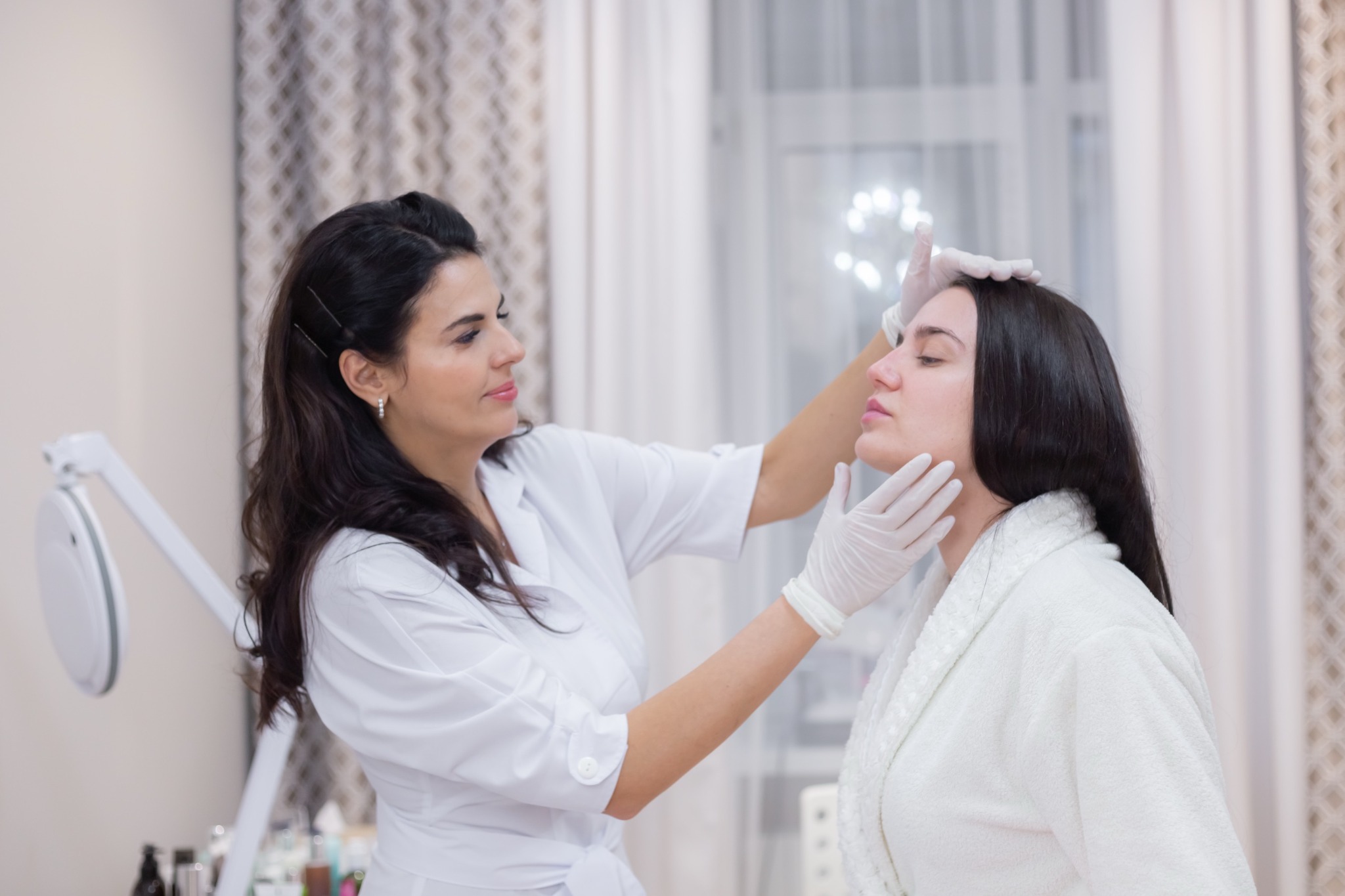 Esteticista médica evaluando la piel del rostro de una paciente en Miami
